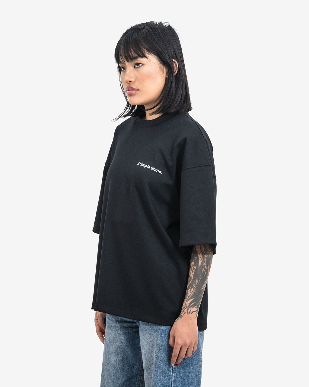 Person wearing a black t-shirt with a logo on a white background