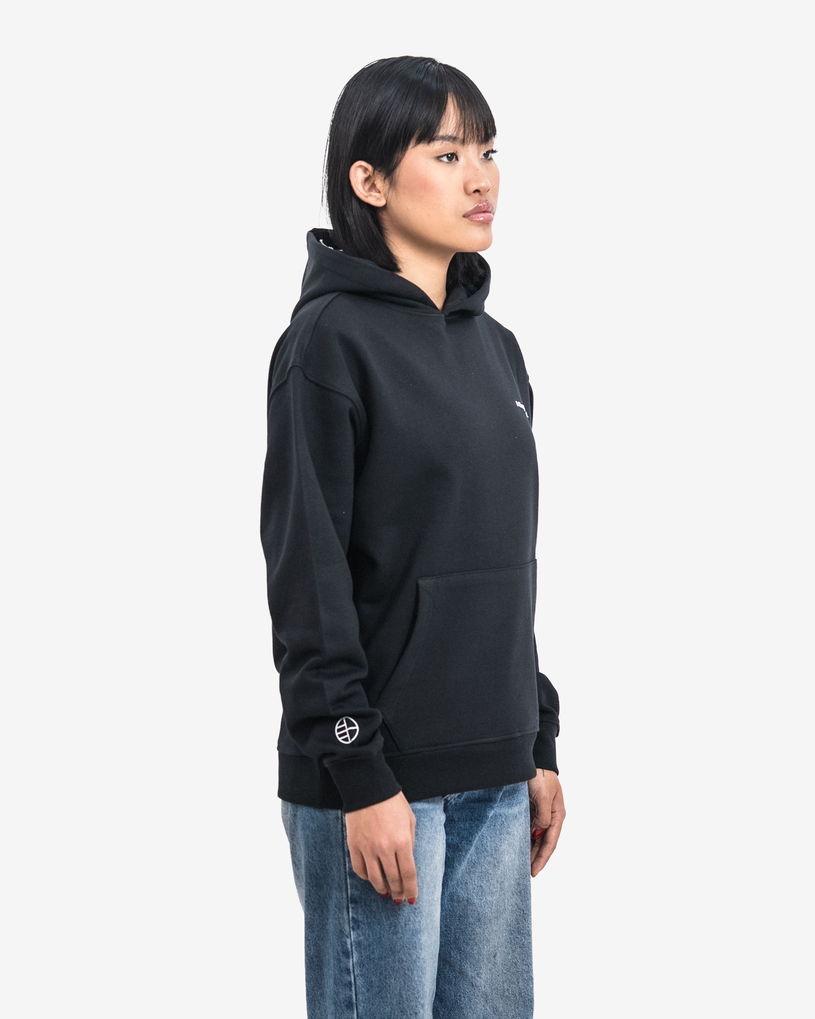 Person wearing a black hoodie with a logo on a white background