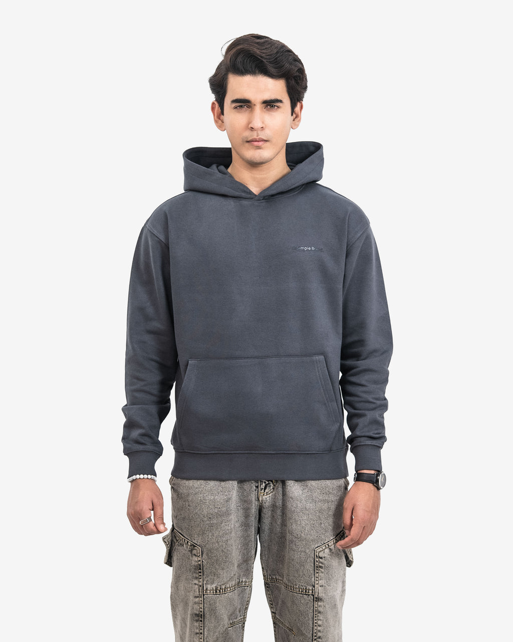 Man wearing a dark gray hoodie with a small logo on a white background