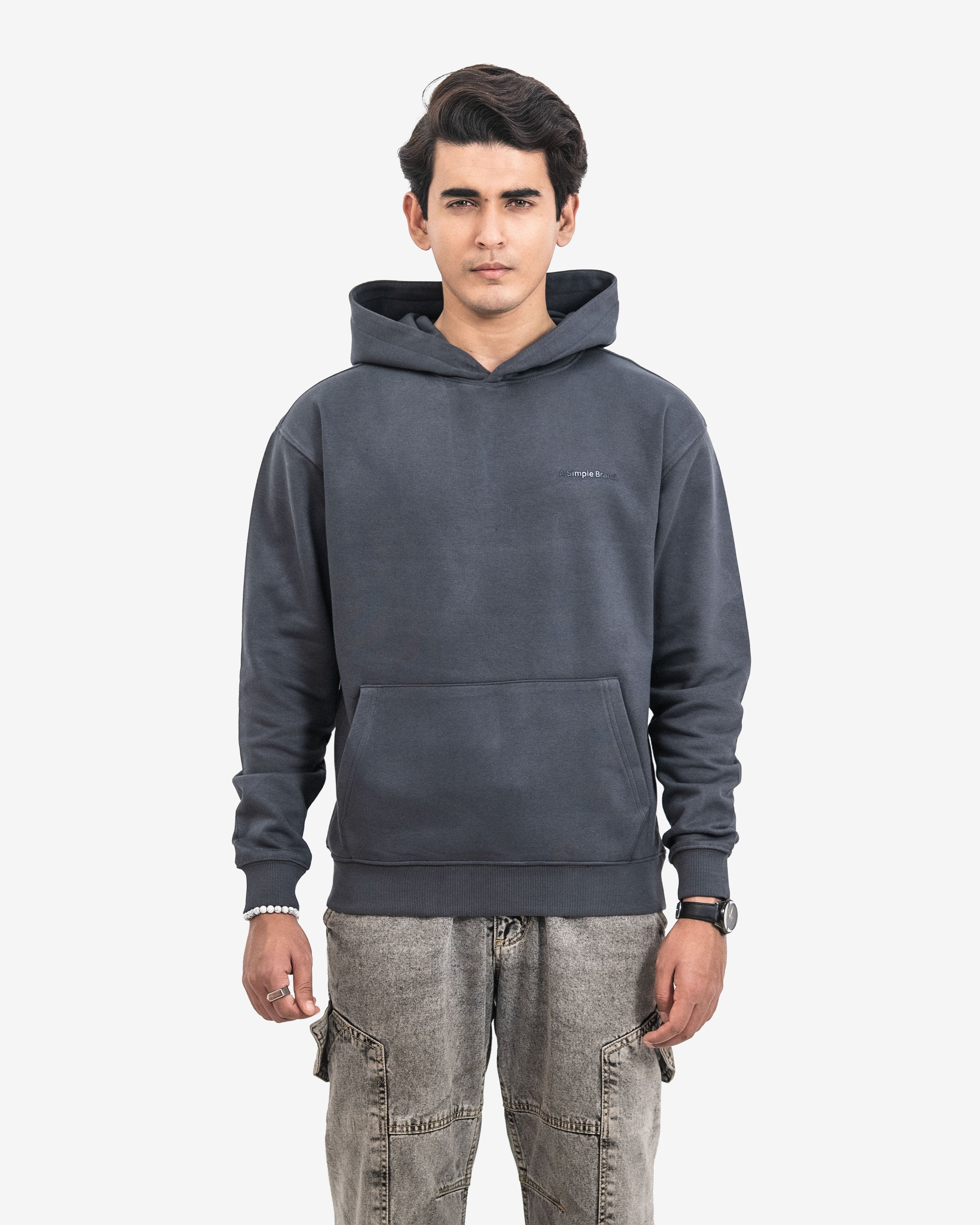 Man wearing a dark gray hoodie with a small logo on a white background