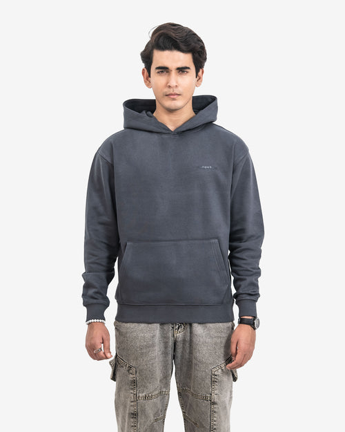 Man wearing a dark gray hoodie with a small logo on a white background