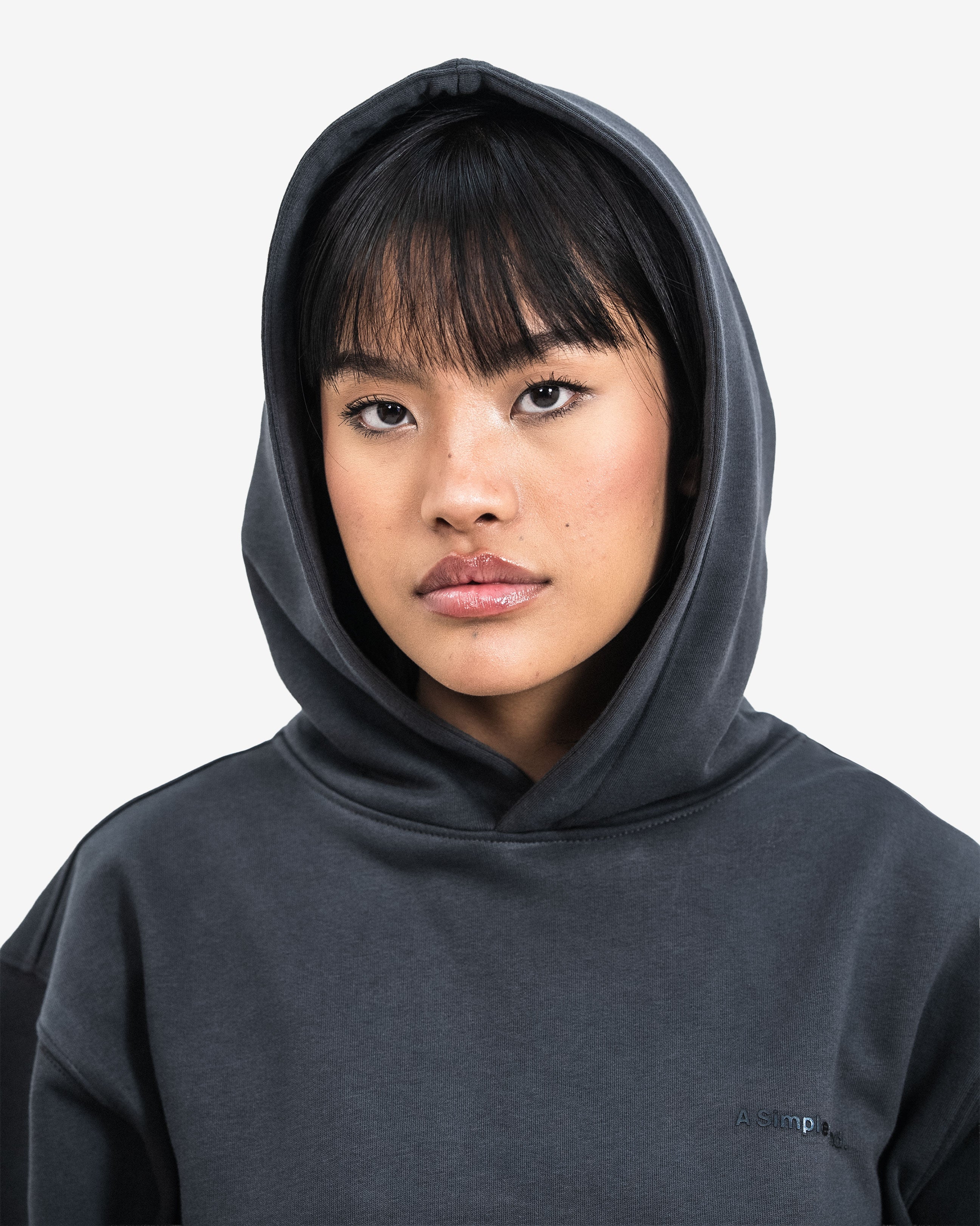 Person wearing a dark gray hoodie with a brand logo.