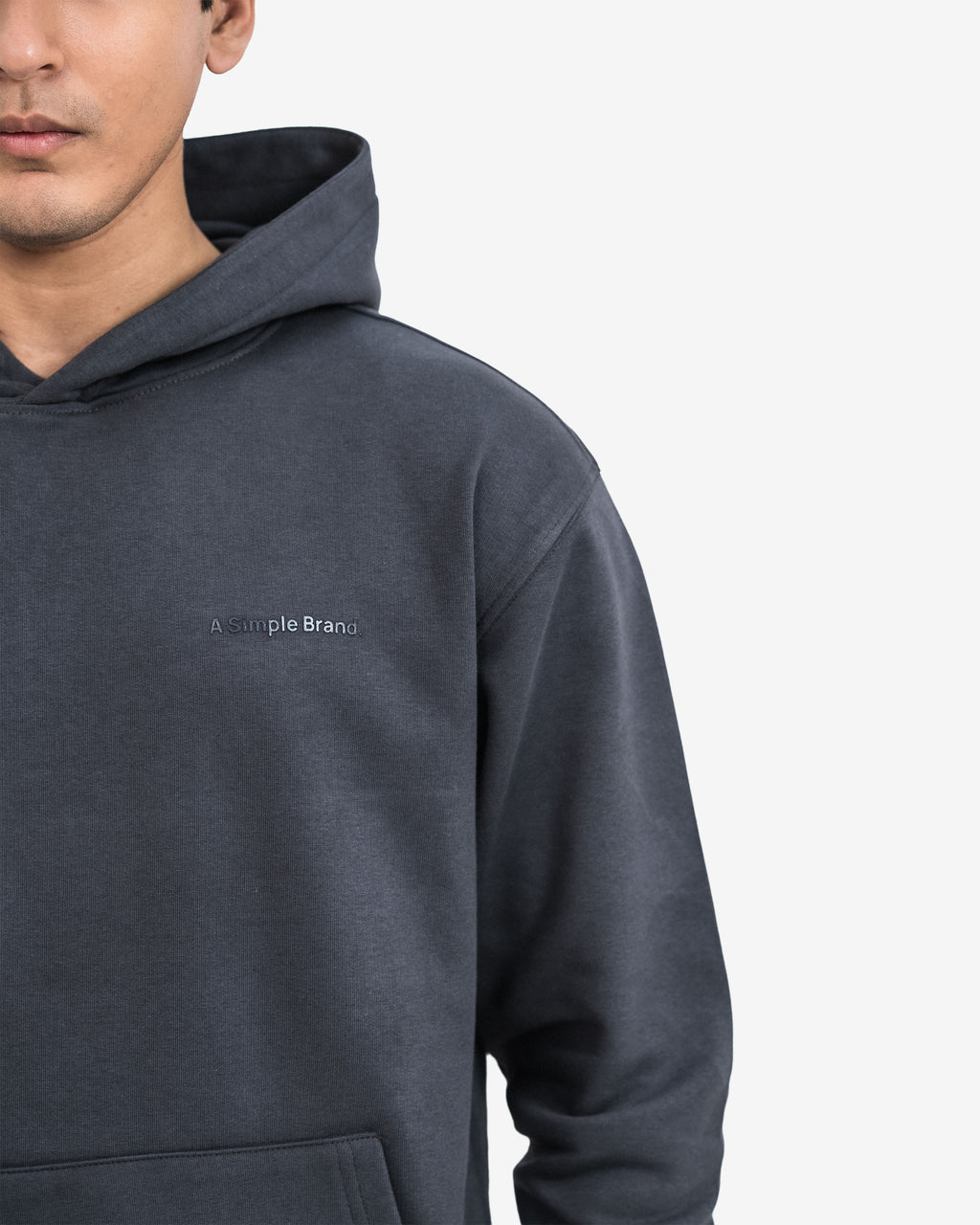 Person wearing a dark gray hoodie with a brand.