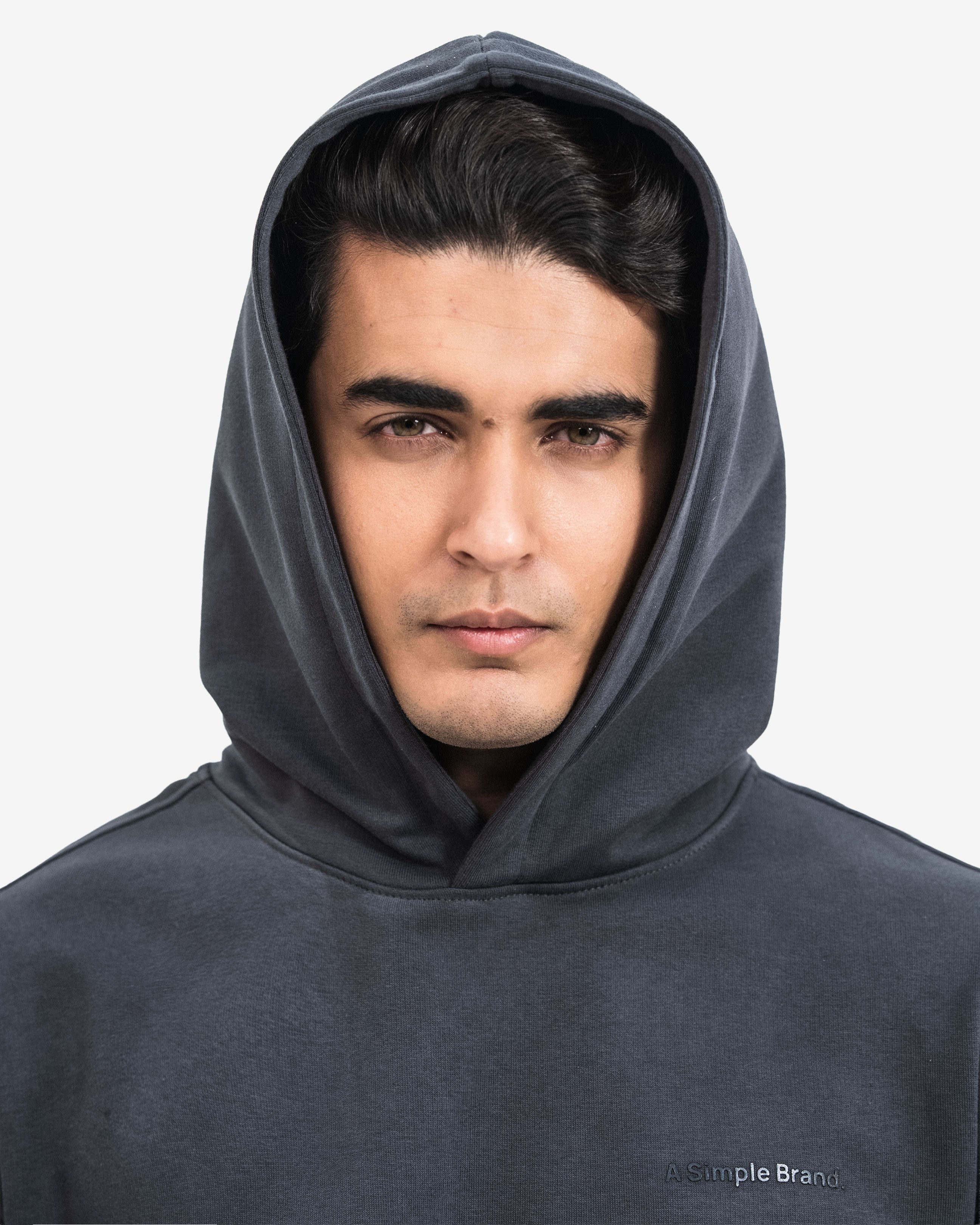 Man wearing a dark gray hoodie against a white background